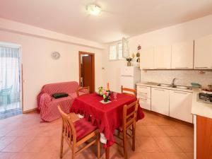 a kitchen with a table with a red table cloth at LES PETITES MAISONS Maison rouge in Procida +7 photos