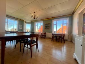 ein Esszimmer mit Tisch, Stühlen und Fenstern in der Unterkunft Sverres Hotel in Rønne