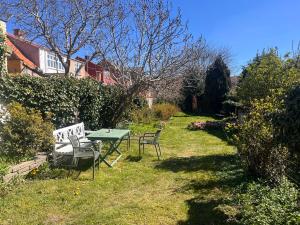 ein Garten mit einem Tisch und Stühlen im Rasen in der Unterkunft Sverres Hotel in Rønne