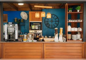 a kitchen with blue walls and a counter top with a counter at Le Kerveguen in Saint-Gilles-les-Bains