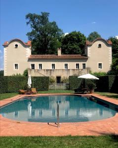 a swimming pool in front of a large house at Maison dans un parc in Parentignat