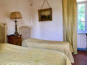 a bedroom with two beds and a lamp and a window at Maison dans un parc in Parentignat