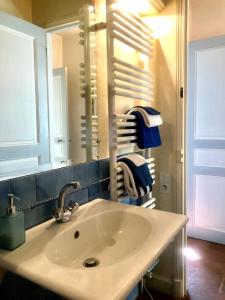 a bathroom with a sink and a mirror and towels at Maison dans un parc in Parentignat +29 photos