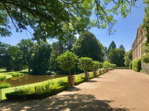 a walkway with a row of trees in a park at Maison dans un parc in Parentignat