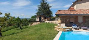 a backyard with a swimming pool and a house at Cabane Wood & Spa in Chasselay