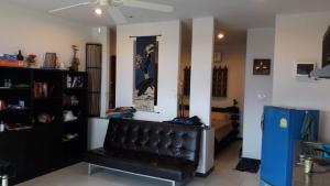 a living room with a black leather bench in a room at bungalow with swimming pool in Rawai Beach