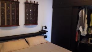 a bedroom with a bed and some books on the wall at bungalow with swimming pool in Rawai Beach