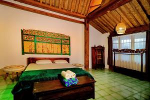 a bedroom with a bed in a room with a table at Kalipura Villa - Private Pool & Nature Escape in Bantul +86 photos