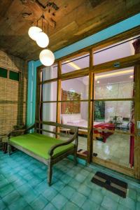 a room with a green bed and a large window at Kalipura Villa - Private Pool & Nature Escape in Bantul