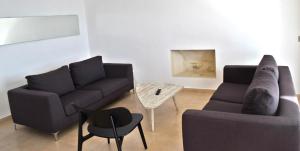 a living room with two couches and a table at Amphora Hotel & Suites in Paphos