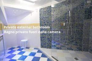 a bathroom with a shower with a blue and white tile floor at CASSIODORO SUITE B&B in Marina di Davoli