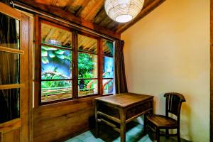 a wooden table and a chair in a room with a window at Kalipura Villa - Private Pool & Nature Escape in Bantul