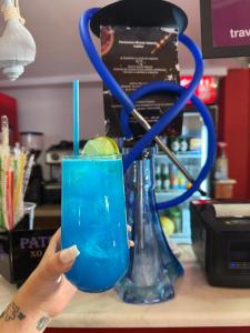 a person holding up a blue drink with a lime at Pensiunea Miruna Valentin in Jupiter +14 photos