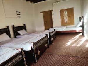 a group of four beds in a room at Hunza Backpackers Inn in Hunza Valley