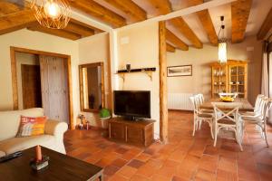 a living room with a television and a table with chairs at Casas de la Fuente in Brieva