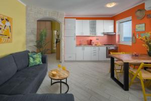 a living room with a couch and a table and a kitchen at Apartment Lemon & Soul in Selce +17 photos