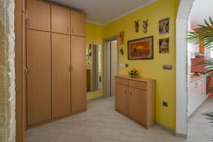 a kitchen with yellow walls and wooden cabinets at Apartment Lemon & Soul in Selce