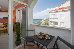 a table on a balcony with a view of the ocean at Apartment Lemon & Soul in Selce