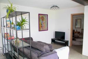 a living room with a couch and a tv at Panoramablick am Herzoghof in Obing