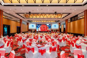 a large banquet hall with white tables and red bows at Equatorial Ho Chi Minh City in Ho Chi Minh City +62 photos