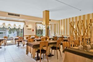 a restaurant with tables and chairs in a room at Hotel Kon Tiki in San Vincenzo