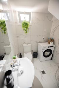 a white bathroom with a toilet and a sink at Aegean View Summer House 1 in Nea Kallikrateia +36 photos