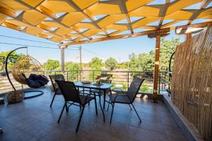 a patio with a table and chairs on a deck at Aegean View Summer House 1 in Nea Kallikrateia