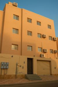 a large orange building with a door and a garage at وحدات الردسي الفندقيه in Jeddah