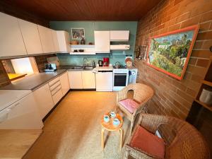 a kitchen with white cabinets and a table at Donau Apartment in Sinzing