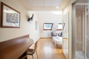 a living room with white walls and a table at Hotel Longoria Plaza by Pandora Hoteles in Oviedo +82 photos