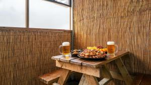 a wooden table with a plate of fruit and beer at Gapyeong Haneuldari pet pension in Gapyeong