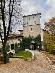 a large stone building with a flag on top of it at Winnica Przybysławice in Przybysławice