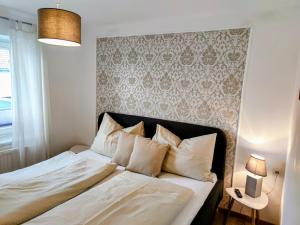 a bedroom with a bed with white sheets and pillows at SPITZAUERs APARTMENTs in Anthering