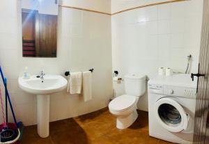 a bathroom with a toilet sink and a washing machine at Cases Tonet 3 in Forcall