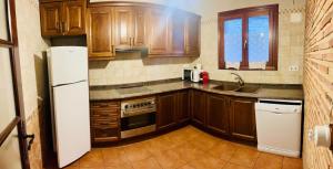 a kitchen with wooden cabinets and a white refrigerator at Cases Tonet 3 in Forcall