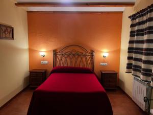 a bedroom with a red bed with two night stands at Cases Tonet 3 in Forcall +9 photos
