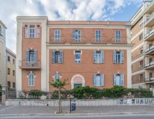 a large red brick building with white windows at Apartment Sole e Luna - Fronte Mare in Nettuno