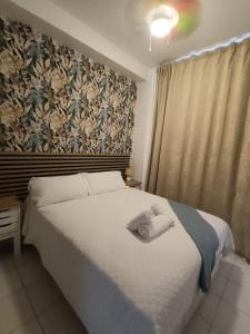 a bedroom with a bed with a towel on it at Bajondillo Beach Apartment By Torremolinos On-line in Torremolinos