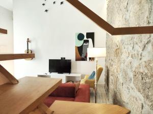 a living room with a red couch and a tv at Villa Santa Bárbara in Vila Nova de Gaia