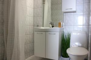 a bathroom with a white sink and a toilet at Grønebakkins smørøye in Beitostøl +16 photos