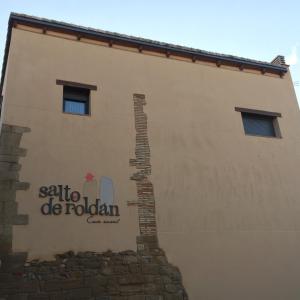 a building with a sign on the side of it at Casa Salto de Roldán in Apiés