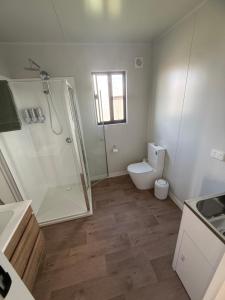 a bathroom with a shower and a toilet and a sink at Peaceful Farm Retreat - Luxury Cabins in Goulburn in Norwood +41 photos