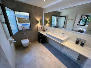 a bathroom with a sink and a toilet and windows at Villa Sa Torre Blanca in Colonia de Sant Pere +57 photos