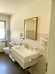 a bathroom with a sink and a mirror and a toilet at Weingut Martin Blaß in Erlabrunn +30 photos
