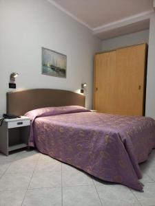 a bedroom with a purple bed and a wooden door at Hotel Susy in Rimini +47 photos