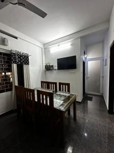 a dining room with a table and chairs and a television at Real Casa in Anachal