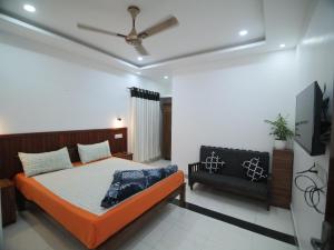 a bedroom with a bed and a couch at Real Casa in Anachal +3 photos