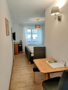 a small living room with a table and a bed at SPITZAUERs APARTMENTs in Anthering