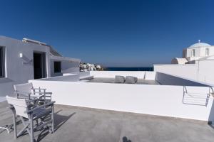 a white house with chairs on the roof at Bedspot Apartments Astipalaia in Pera Gyalos