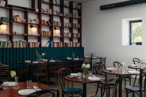 a dining room with tables and chairs and a book shelf at Resort po.spolu in Mokrovraty